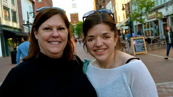 Photo of the author and her mother smiling for the camera, on a street in front of a restaurant.
