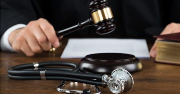 Judge in position to bang a gavel, with a piece of paper and a stethoscope in front of him.