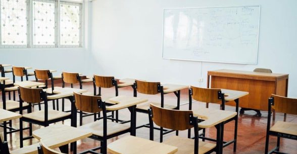 Empty School classroom with wooden desks, chairs, and whiteboard