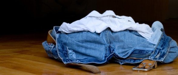 A pile of clothes - underwear, jeans, and a belt - on the floor.