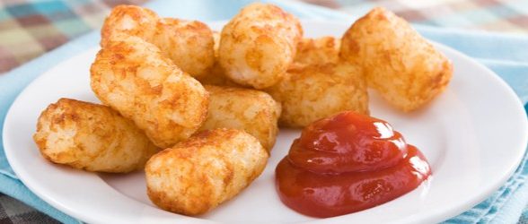 A plate of tater tots with a dollop of ketchup.