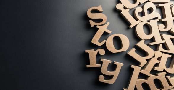 The word story spelled out in wooden letters, surrounded by other randomized wooden letters.