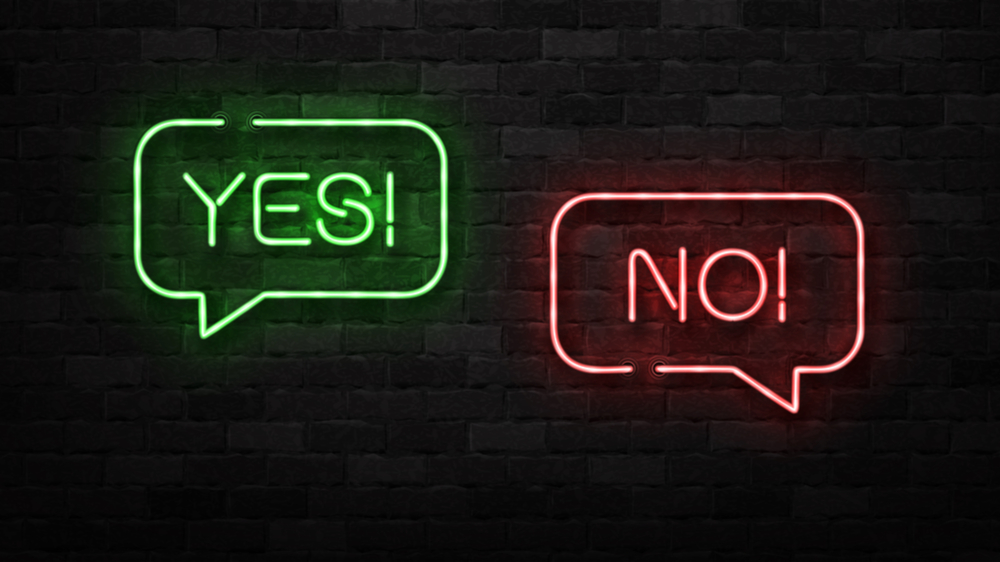 Two neon signs in the shape of speech bubbles. One says yes, one says no.
