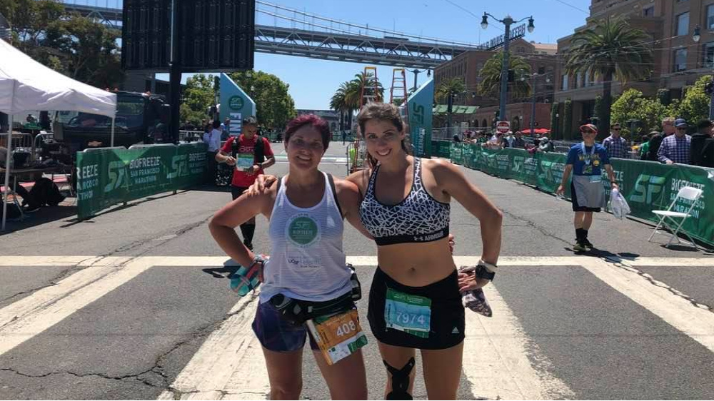 Photo of Amy and friend, both pausing from running.