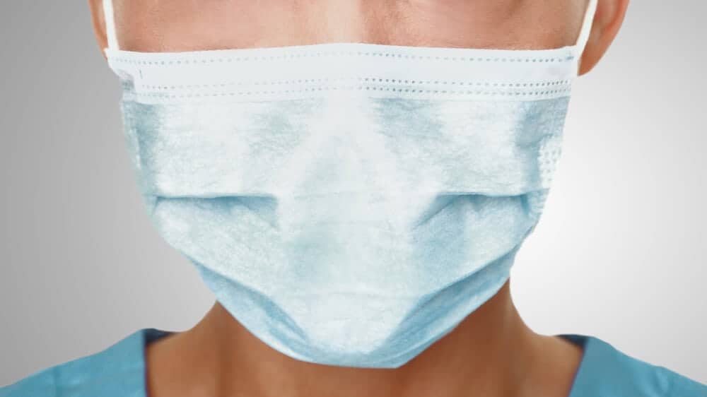 The lower half of a person's face, covered in a surgical mask.