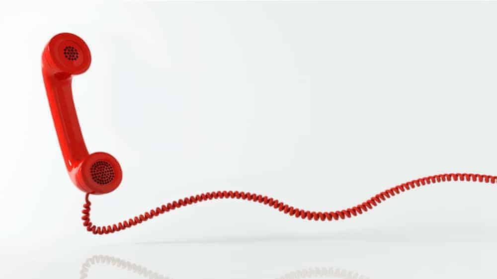 A red telephone receiver with a long red wire