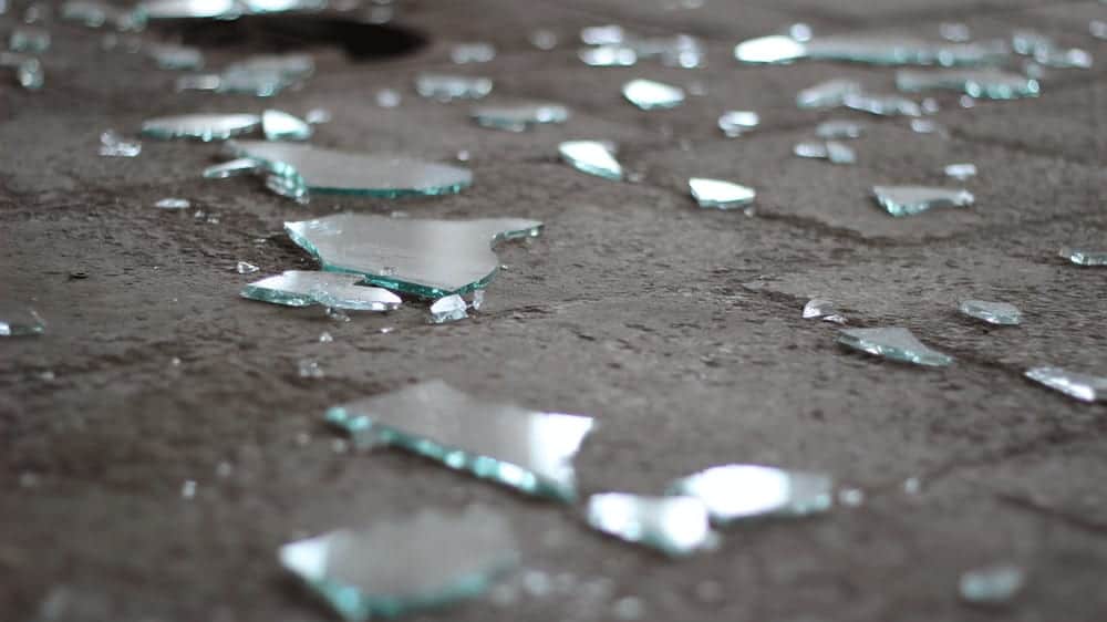 Shards of broken glass scattered on a gray floor.