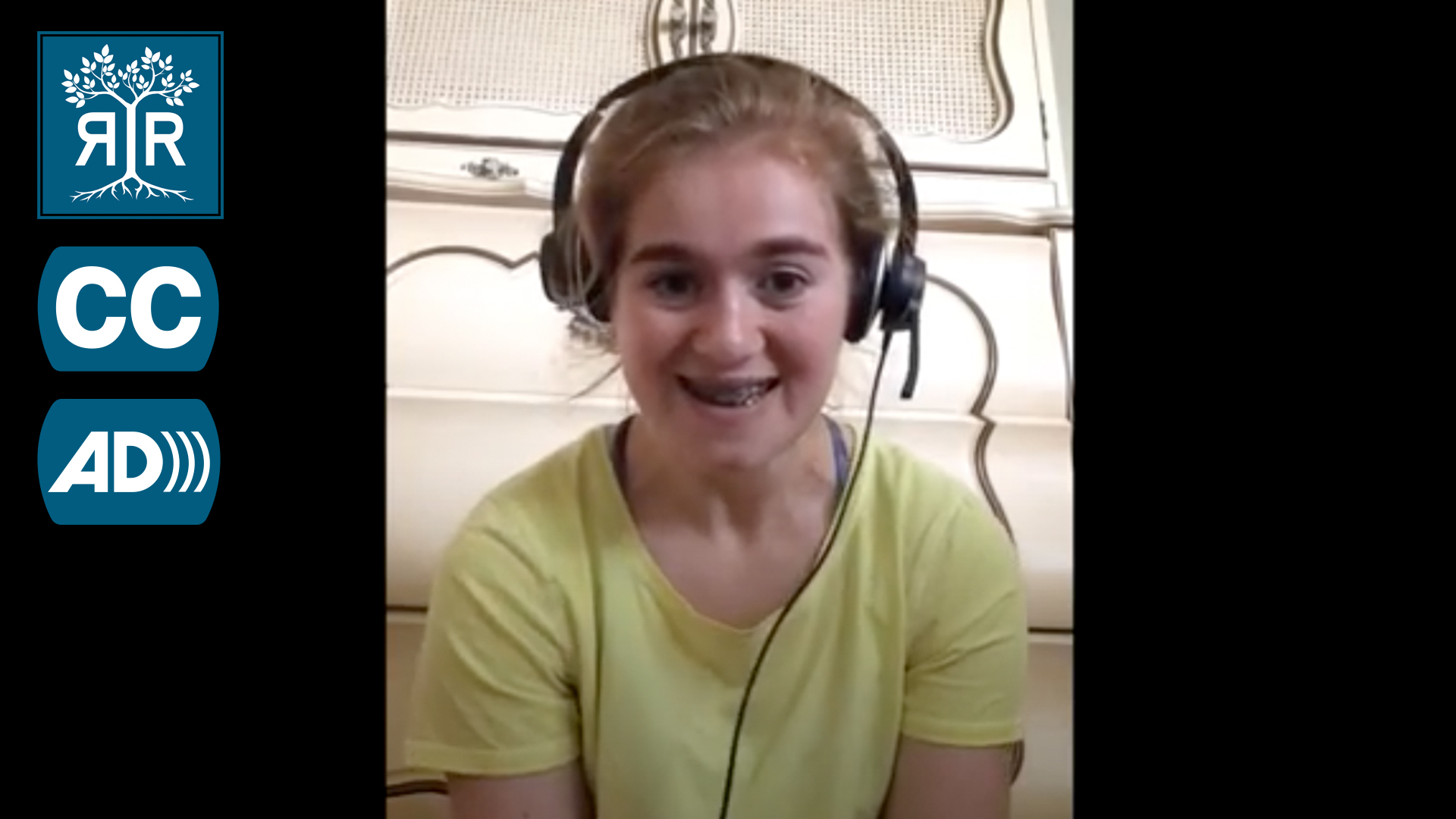 Clarice smiles while smiling to camera. She is wearing headphones with a mic.