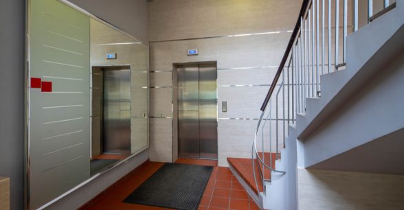 An elevator next to a staircase inside an apartment building.