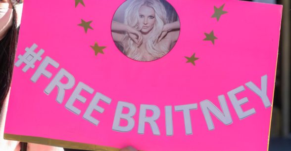 Bright pink sign with photo of Britney Spears that says #FreeBritney