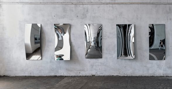 A row of curved mirrors that distort reflections.
