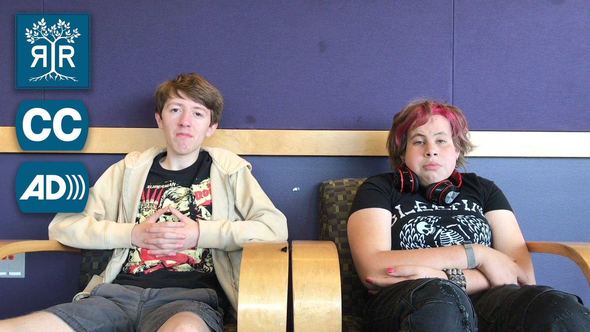 Two students sit in chairs facing the camera
