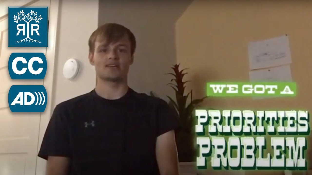 Michael speaks to camera from a room. On-screen text to the right reads, "We got a priorities problem";. The text is in all capital letters and is white with a neon green border.